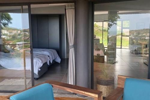 a bedroom with a bed and sliding glass doors at Cormorants' View Self Catering accommodation in Sedgefield