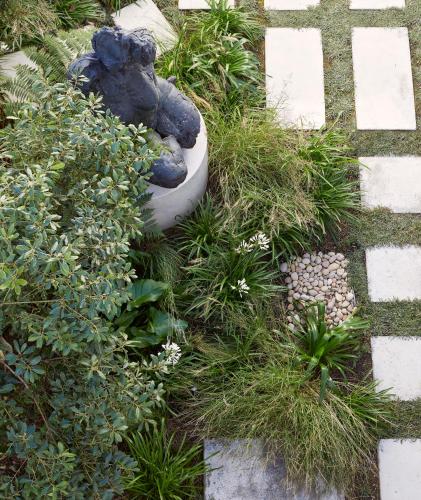 a garden with a teddy bear sitting on the grass at Walkers Beach in Plettenberg Bay