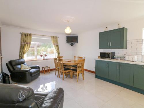 a kitchen and living room with a table and chairs at Teach Annie Agus Paddy in Gortahork