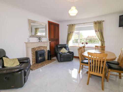 a living room with a table and chairs and a fireplace at Teach Annie Agus Paddy in Gortahork