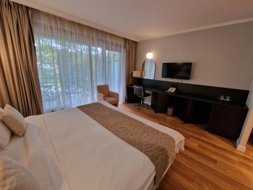 a hotel room with a bed and a flat screen tv at Hotel Sunny Hill in Cluj-Napoca