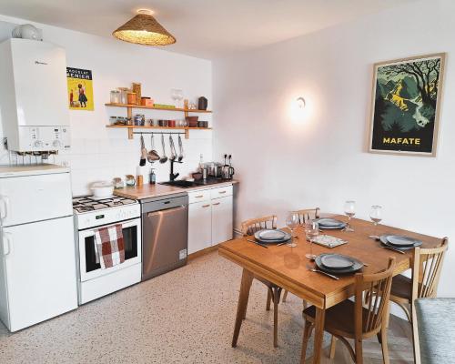 Il comprend une cuisine avec une table en bois et des appareils électroménagers blancs. dans l'établissement L'agave - Rennes Quartier Anatole France, à Rennes