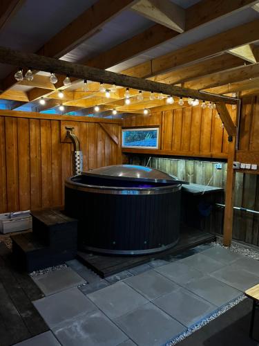 a large hot tub in a room with a wooden ceiling at Apartament Pod Górką Gołdap II in Gołdap