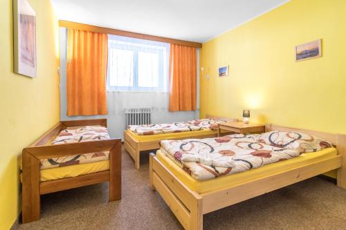 a group of three beds in a room at Penzion Vápenka in Horní Maršov