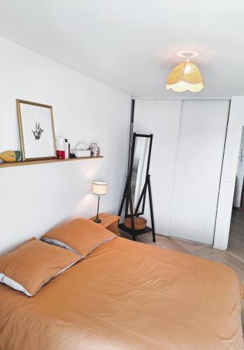 une chambre avec un lit et un miroir au mur dans l'établissement L'agave - Rennes Quartier Anatole France, à Rennes