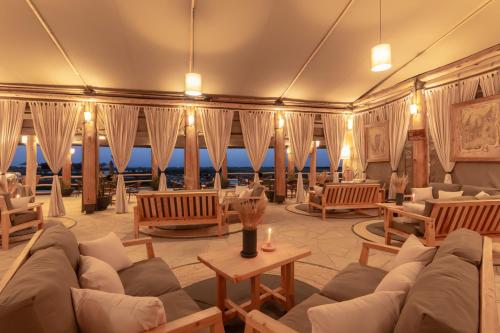 a living room with couches and tables and windows at MAISHA SWEETWATERS CAMP in Ol Pejeta Conservancy