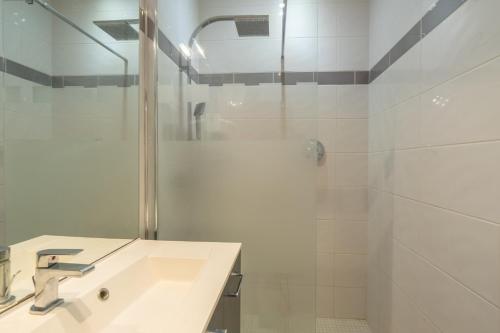 a white bathroom with a sink and a shower at Meschers in Saint-Simon-de-Bordes