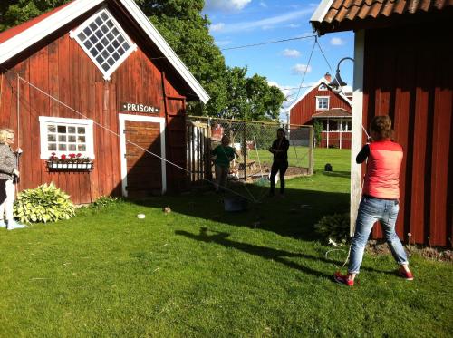 a woman flying a kite in front of a red barn at Äventyrsgårdens Vandrarhem, Kinnekulle in Källby