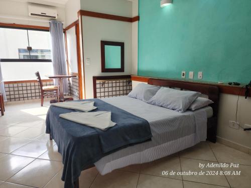 a bedroom with a bed with a blue wall at Hotel São Charbel in Ubatuba