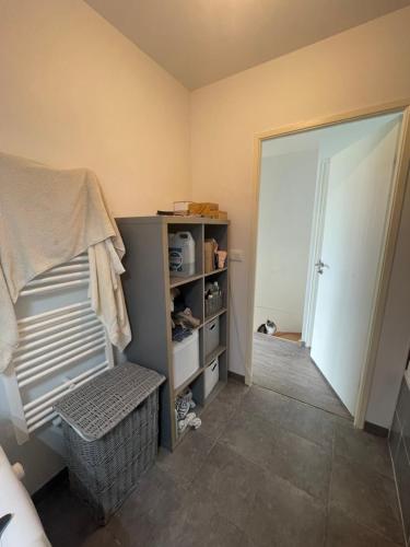 Cette chambre dispose d'un placard avec une porte et une étagère. dans l'établissement Appartement type T2, à Neuilly-Plaisance