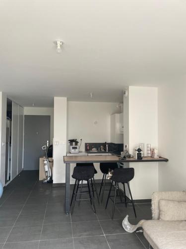 une cuisine et un salon avec une table et des chaises dans l'établissement Appartement type T2, à Neuilly-Plaisance