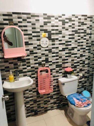 een badkamer met een wastafel, een toilet en een spiegel bij Apartamento Acogedor in San Felipe de Puerto Plata