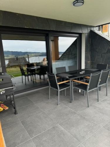 a dining room with a table and chairs and a balcony at Porębiańska Osada Resort & Spa in Szlembark