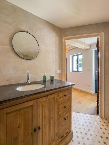 une salle de bain avec un lavabo et un miroir dans l'établissement Aux Petits Bourgeons, à Adainville