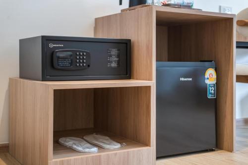 a microwave and a refrigerator in a wooden cabinet at Upstairs at Ton Ton in Bangkok