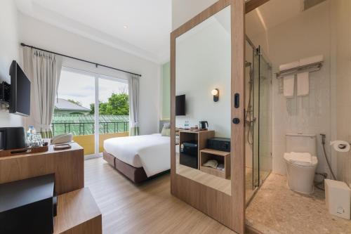 a bedroom with a bed and a bathroom with a shower at Upstairs at Ton Ton in Bangkok