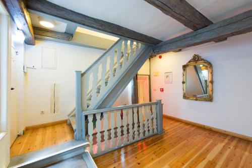 a hallway with a staircase and a mirror at Hotel Theophano in Quedlinburg