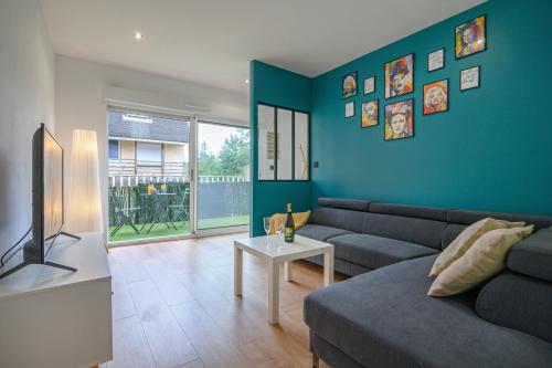 a living room with a couch and a table at Le Louvre Lens - Premium - Wifi - Balcon & Parking in Lens