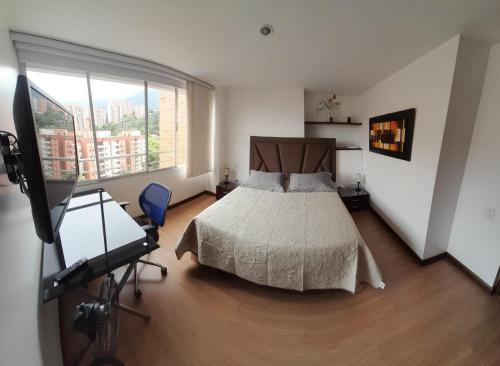 a bedroom with a bed and a large window at Lujoso y Economico Apartamento in Envigado