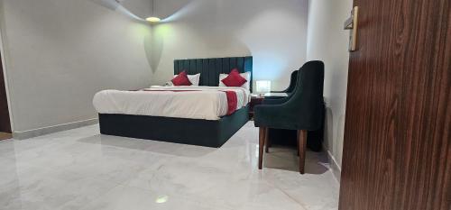a bedroom with a bed with a chair and a table at Hotel K9 Regency sirsa in Sirsa