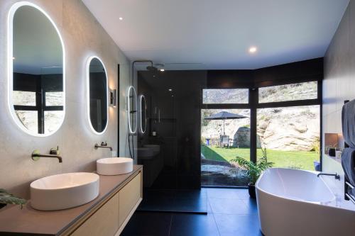 a bathroom with two sinks and two mirrors at Beautiful Haven - Stunning Luxury Home - Queenstown - NEW!! in Queenstown
