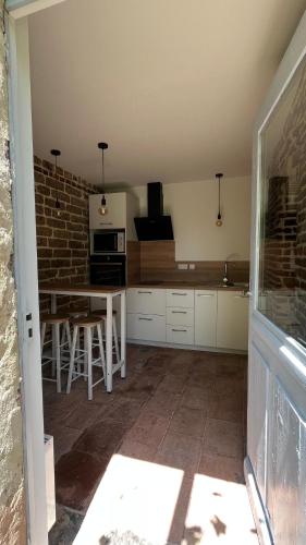 a kitchen with a table and a brick wall at La vieille ferme de Gaillac in Gaillac