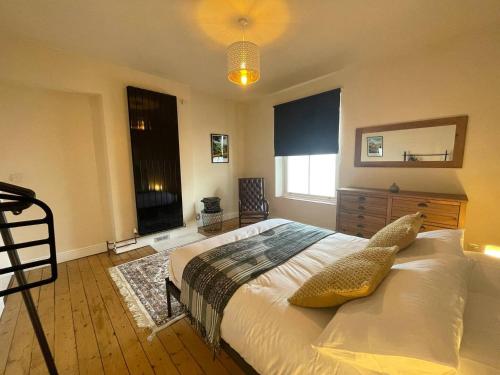 New MillsPass the Keys Pet & Cycle Friendly Garden Home in New Mills的带床、梳妆台和窗户的卧室