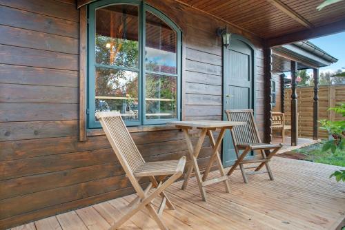 a wooden deck with two chairs and a wooden table at Blockbohlen-Haus auf Hof Verchen in Verchen