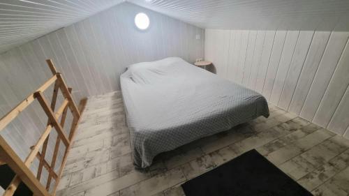 a small bed in a room with a staircase at La Mezzanine - 2-4 pers - Centre-Ville in Brassac-les-Mines