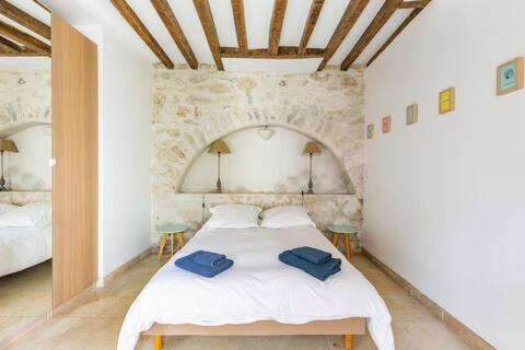 a bedroom with a bed with two blue towels on it at Ferme de Pontaly in Bailly