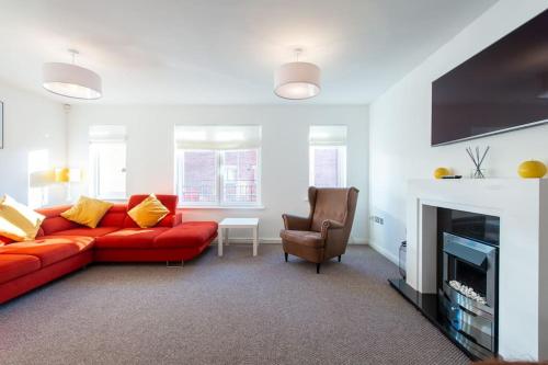 a living room with a red couch and a chair at City centre 4 Bed house FREE parking walk to town in Cardiff