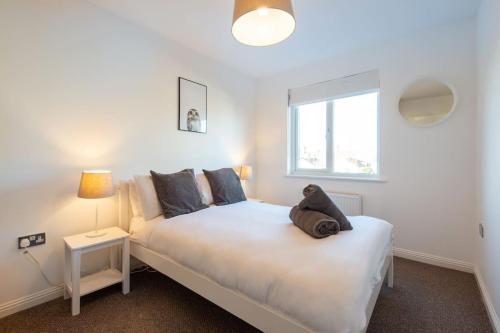 a bedroom with a white bed and a window at City centre 4 Bed house FREE parking walk to town in Cardiff