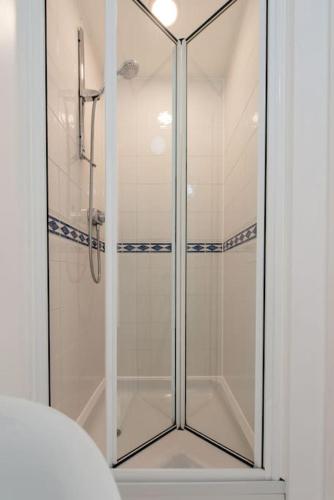 a shower with a glass door in a bathroom at City centre 4 Bed house FREE parking walk to town in Cardiff