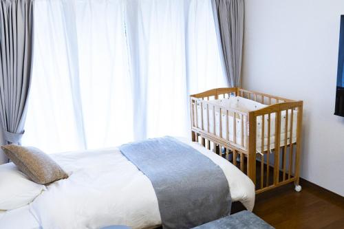a baby crib in a bedroom with a crib at The CATAN 石垣島 in Nagura
