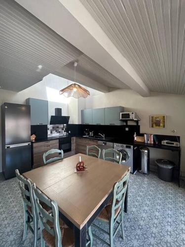une cuisine avec une table et des chaises en bois dans l'établissement La maison n1 Arles terrasse, à Arles