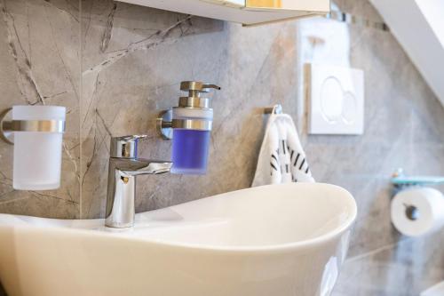 a bathroom sink with a blue soap dispenser on it at Ferienwohnung Familie Süttner in Nagel