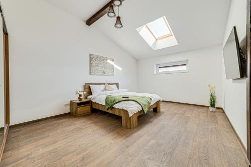 a white bedroom with a bed and a skylight at ARI Central Grand Apartments - Luxurious Stay in Arad