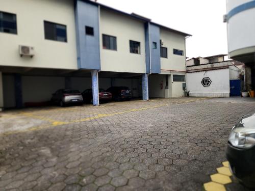 a building with cars parked in a parking lot at Hotel São Charbel in Ubatuba