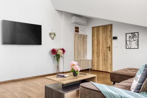 a living room with a couch and a tv at ARI Central Grand Apartments - Luxurious Stay in Arad