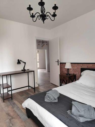 une chambre avec un lit, une table et un lustre dans l'établissement Lafabrik, à Valence