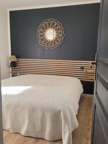 une chambre avec un lit et un miroir au mur dans l'établissement Appartement face au golf en rez de jardin, au Cap d'Agde
