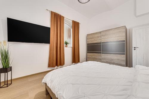 a bedroom with a white bed and a large window at ARI Central Grand Apartments - Luxurious Stay in Arad