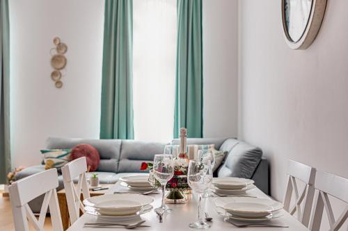 a dining room with a table with plates and wine glasses at ARI Central Grand Apartments - Luxurious Stay in Arad
