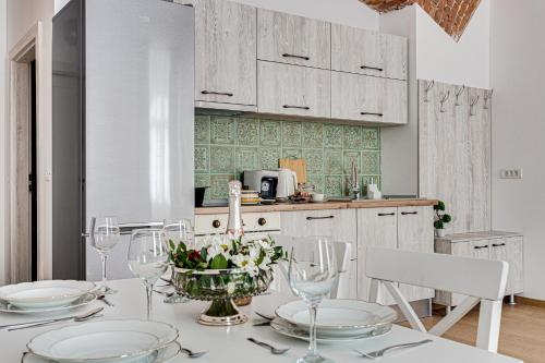 a kitchen with a table with glasses and flowers on it at ARI Central Grand Apartments - Luxurious Stay in Arad