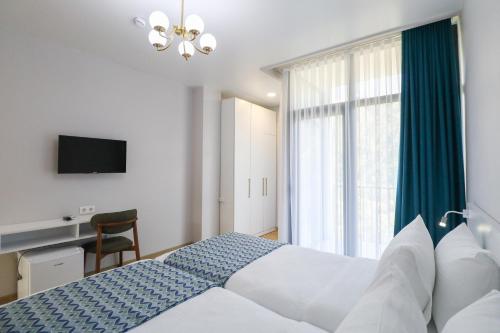 a bedroom with a bed and a large window at Hotel & Restaurant Emerald Borjomi in Borjomi