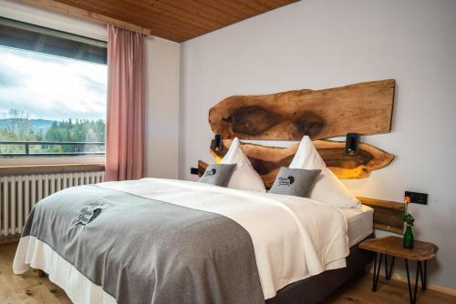 a bedroom with a large bed with a large window at Boutique Hotel and Apartments Pension Sternen in Todtmoos