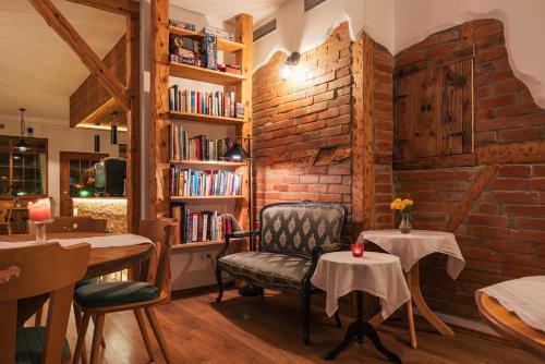 a room with a brick wall and a chair and tables at Boutique Hotel and Apartments Pension Sternen in Todtmoos