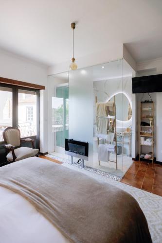 a bedroom with a large bed and a fireplace at Guesthouse Arieira Escapadinha Exclusiva na Natureza in Aguda