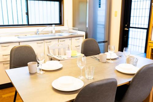 a table with plates and glasses on it in a kitchen at The CATAN 石垣島 in Nagura