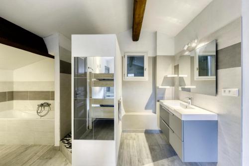 La salle de bains blanche est pourvue d'un lavabo et d'une baignoire. dans l'établissement House with view Ulysse, à Saignon